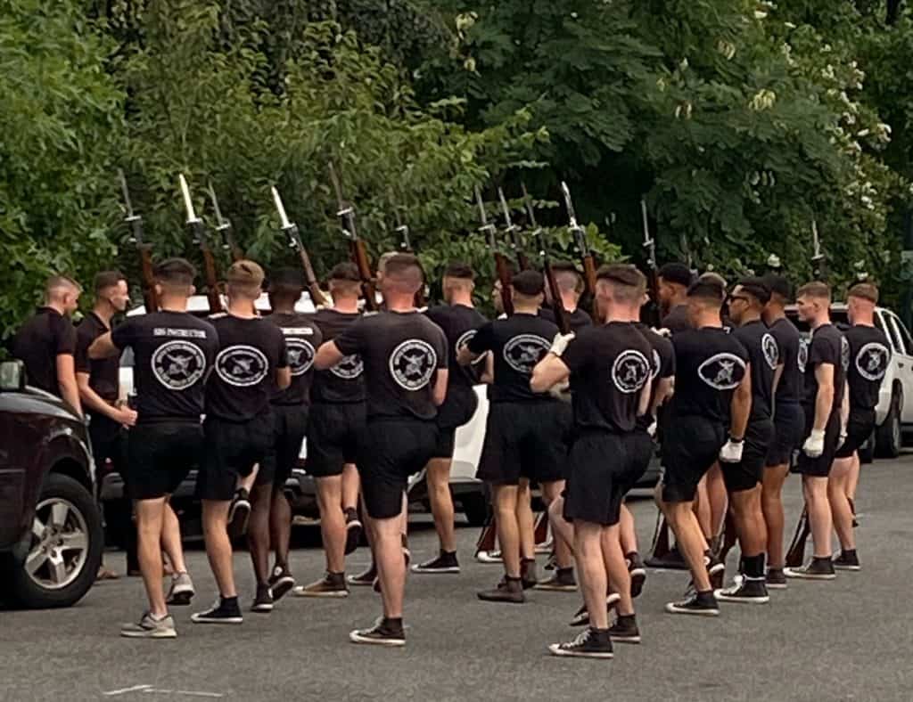 Several Marines practicing formation in the street before the Friday evening parade