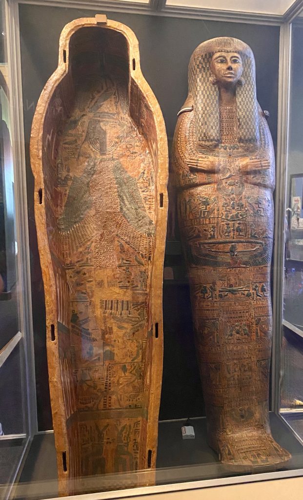 Top and botton of wooden mummy coffin in a glass case