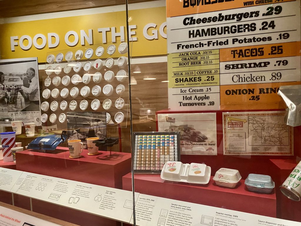 plastic coffee cup lids, fast food menu, and styrofoam fast food containers in display case at National Museum of American History in Washington DC