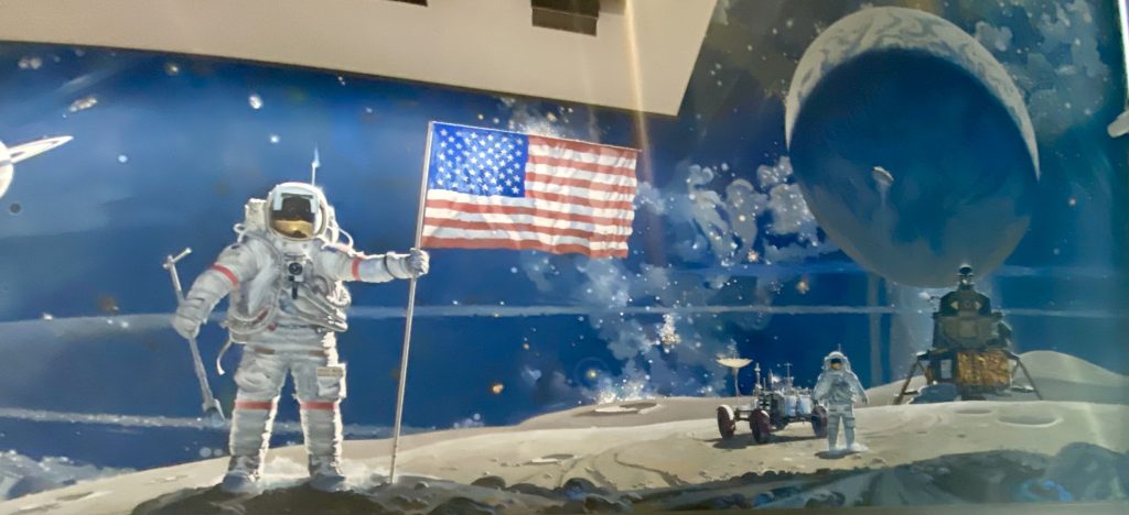 Large mural of astronaut planting American flag on the moon with a second astronaut, a lunar rover vehicle, a lunar module, and the Earth in the background