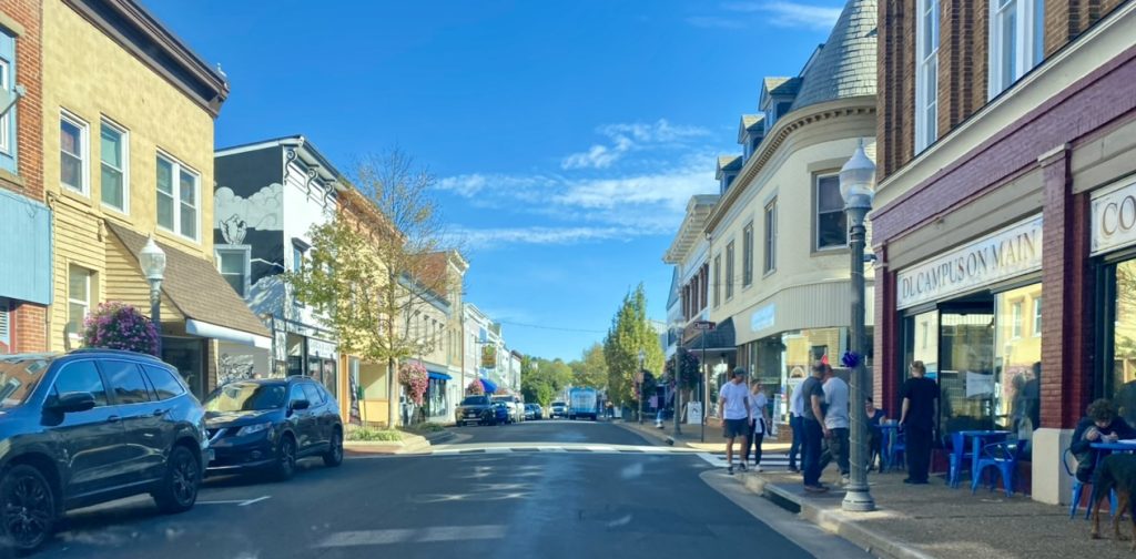 Main Street in downtown Front Royal Virginia lined with storefronts, cars, and people on the sidewalks