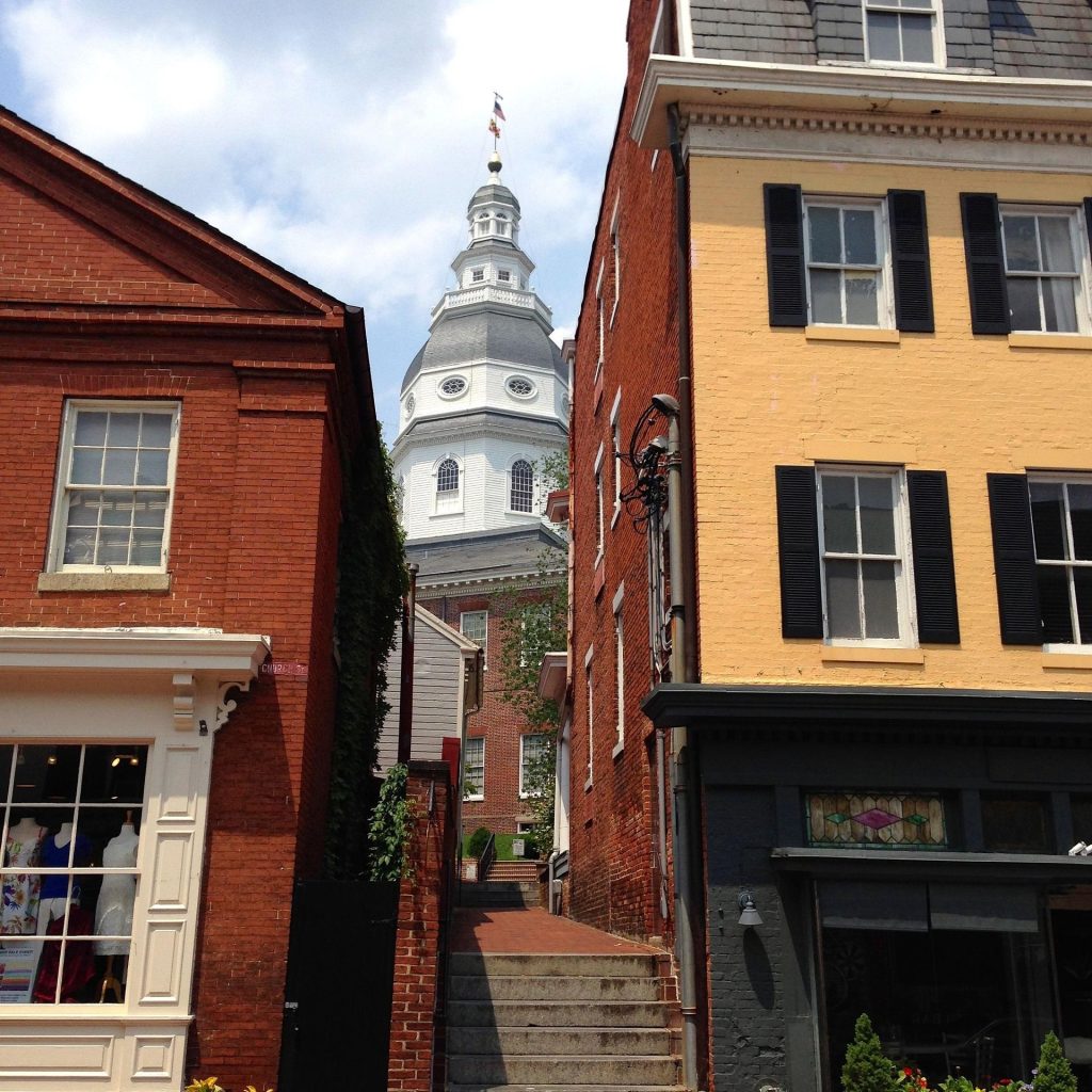 Domed statehouse building between two store fronts in Annapolis, Maryland