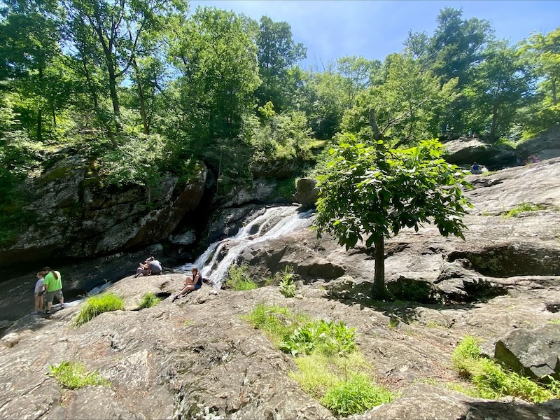 People sitting along the waterfall at Cunningham Falls in Maryland